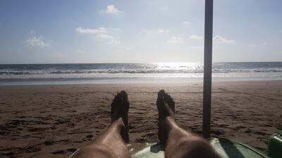 photo of my legs with the beach and sea in the background